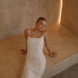 White low back maxi dress with tassels all over the dress & strap and a side split | Gina Kim