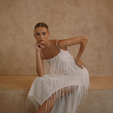 White low back maxi dress with tassels all over the dress & strap and a side split | Gina Kim