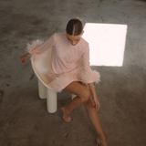 A round neckline pink sequin mini dress with ostrich feathers around the 3/4 sleeves and the skirt hemline | Gina Kim