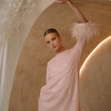 A round neckline pink sequin mini dress with ostrich feathers around the 3/4 sleeves and the skirt hemline | Gina Kim