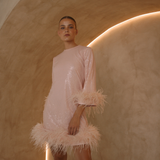 A round neckline pink sequin mini dress with ostrich feathers around the 3/4 sleeves and the skirt hemline | Gina Kim
